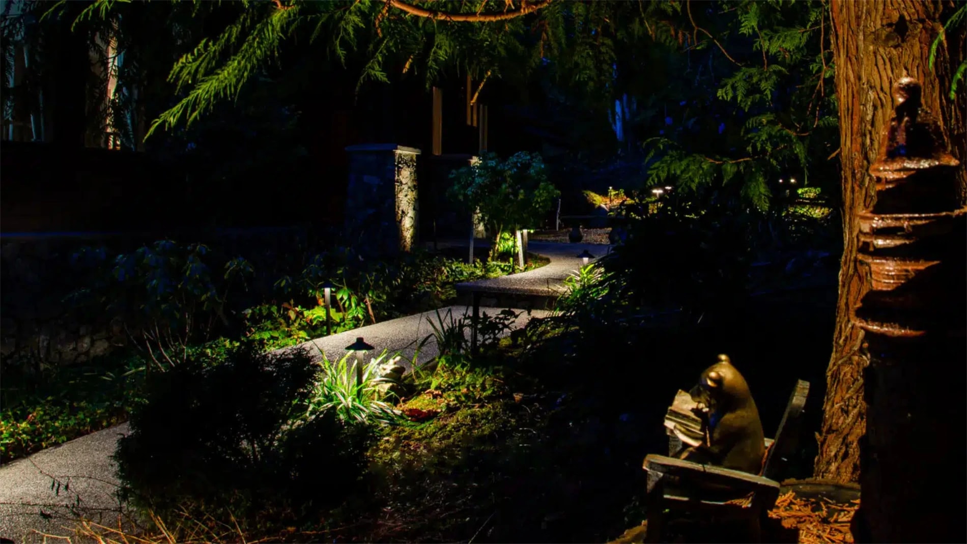 a Victoria garden/pathway lit up at night by professional landscape lighting